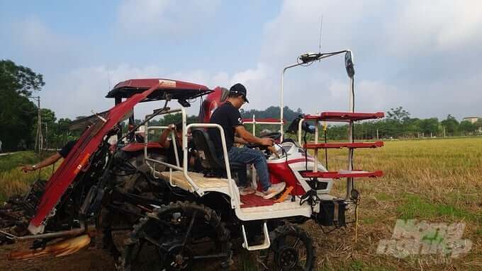 Nhân viên Công ty Đại Thành lắp đặt thiết bị dẫn đường NX510 cho 2 chiếc máy cày, máy cấy của gia đình anh Sơn tại thôn Thanh Nê, xã Yên Lợi. Ảnh: Kiên Trung.